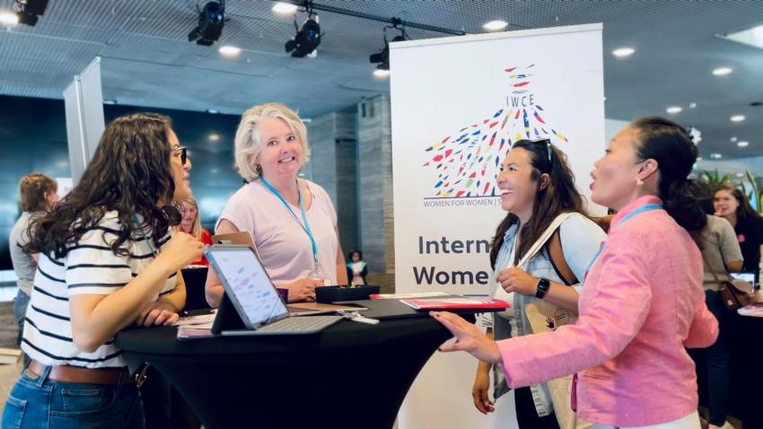 A group of women chatting at the IWCE stand
