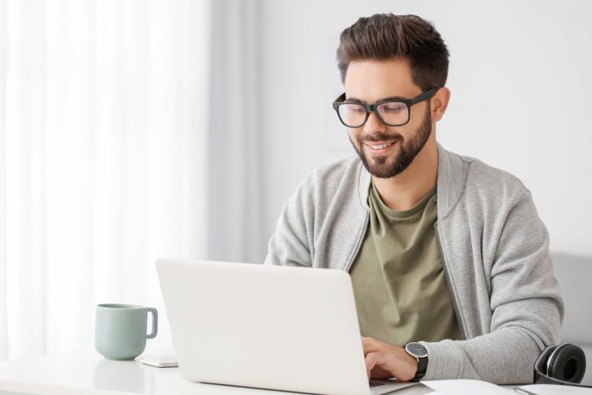 A man sitting at a desk working on a laptop