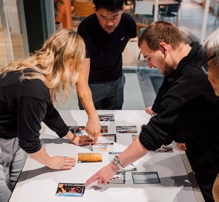 People standing round a table looking at cards