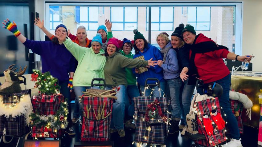 A group of smiling women in woolly hats