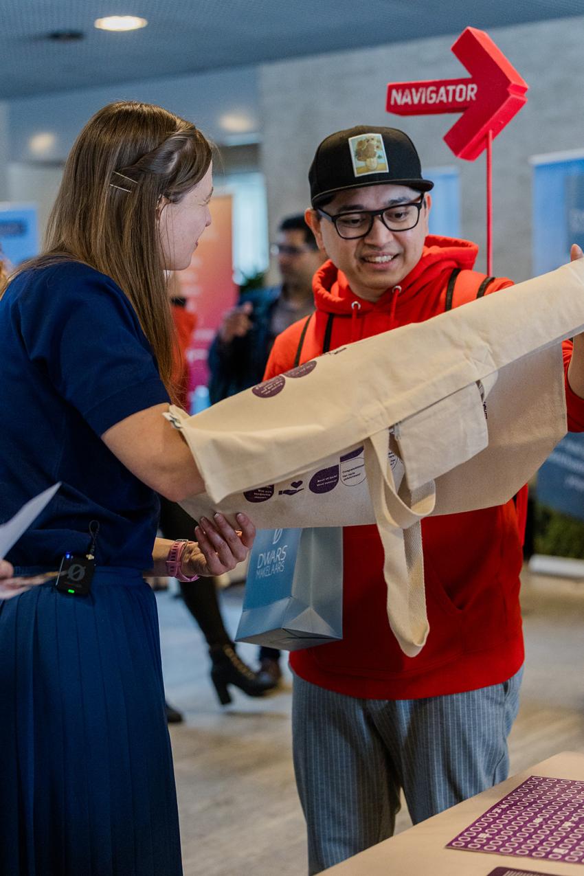 A woman and a man from Eindhoven Navigators viewing a cheat-sheet bag
