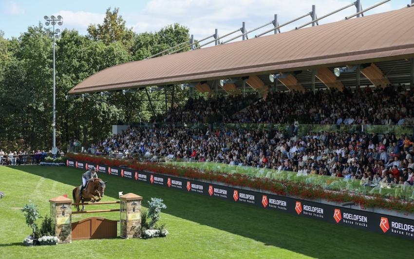 Horse and rider showjumping in an arena with spectators