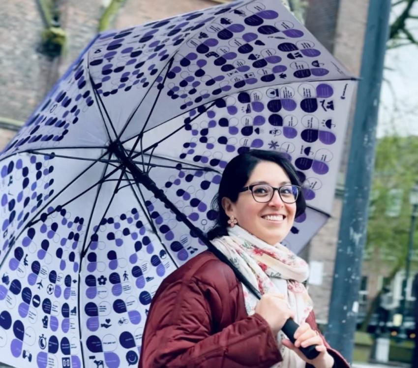 A smiling lady holding a cheat-sheet umbrella