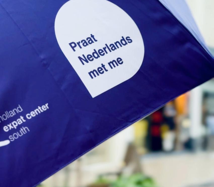 Purple cheat-sheet umbrella saying Praat Nederlands met me