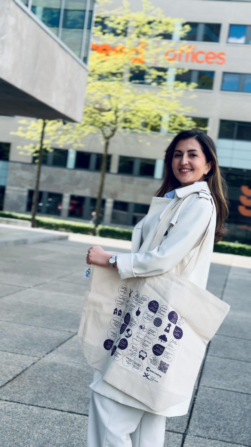 Smiling woman with a Praat Nederlands Met Me beach tote bag