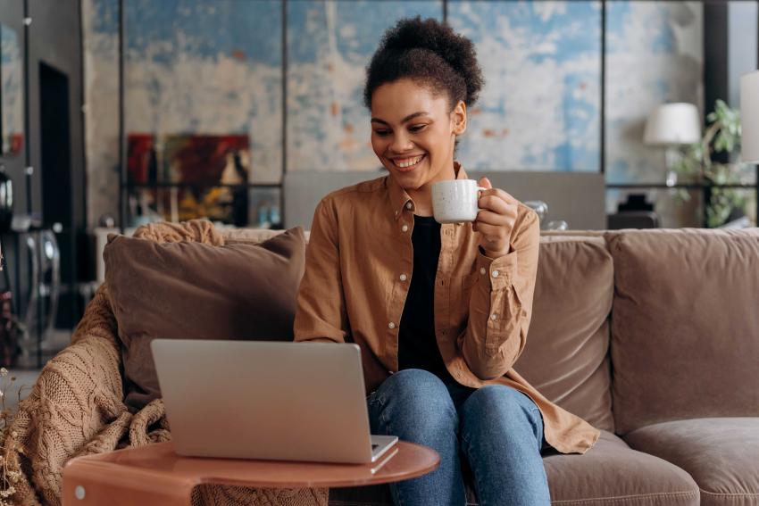 A smiling woman sitting at a laptop