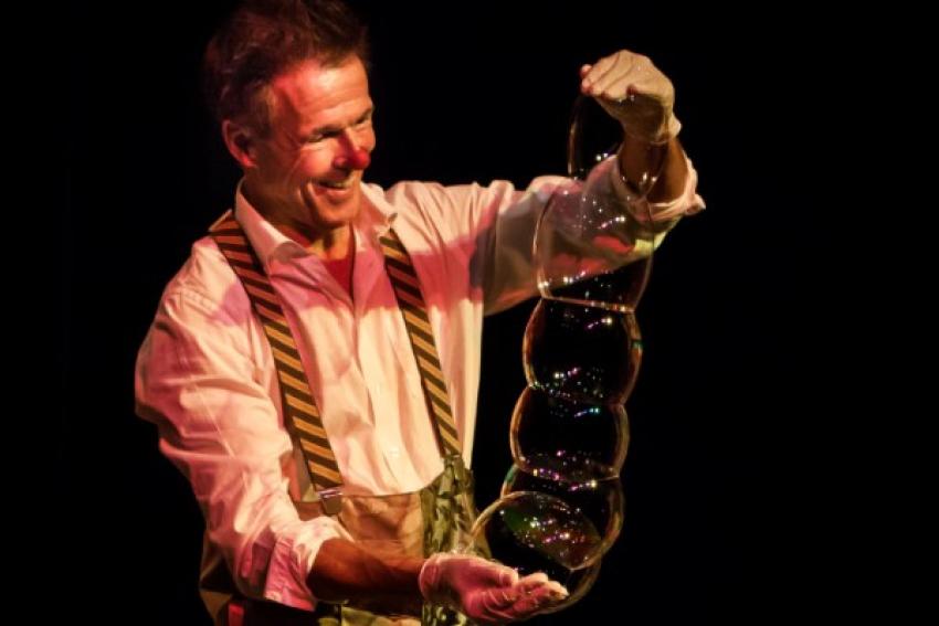 A clown holding bubbles