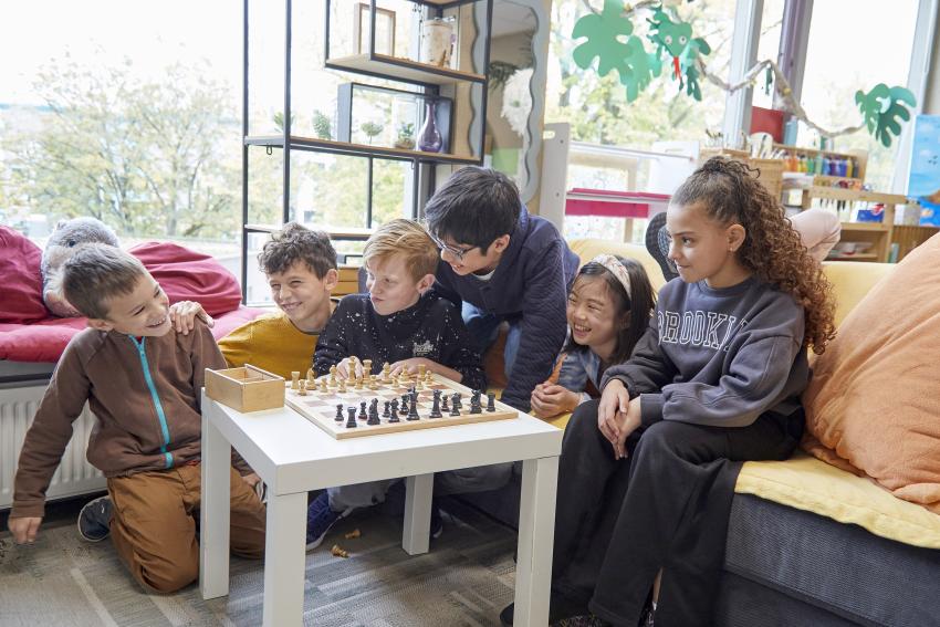 Smiling children playing a game of chess