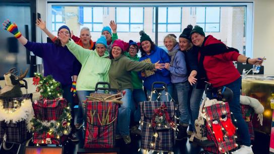 A group of smiling women in woolly hats, klik voor een vergroting