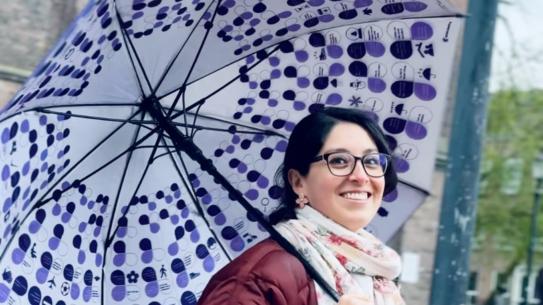 A smiling lady holding a cheat-sheet umbrella, klik voor een vergroting