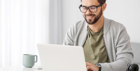 A man sitting at a desk working on a laptop