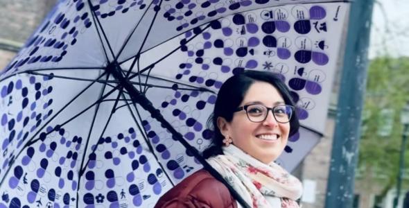 A smiling lady holding a cheat-sheet umbrella