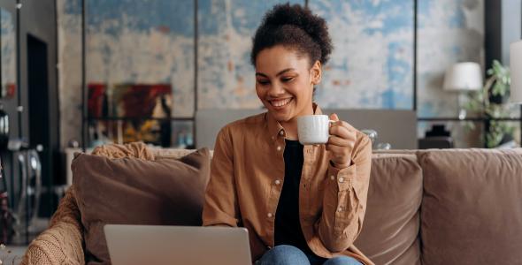 A smiling woman sitting at a laptop