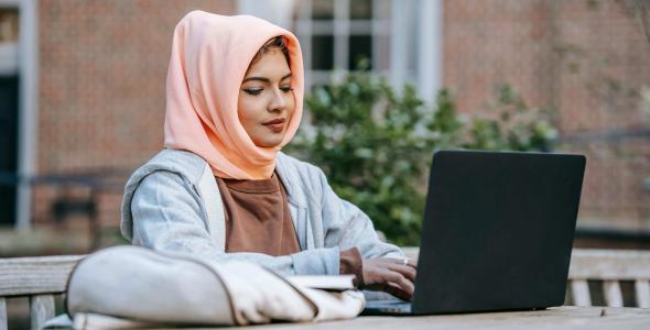 A smiling woman sitting at a laptop